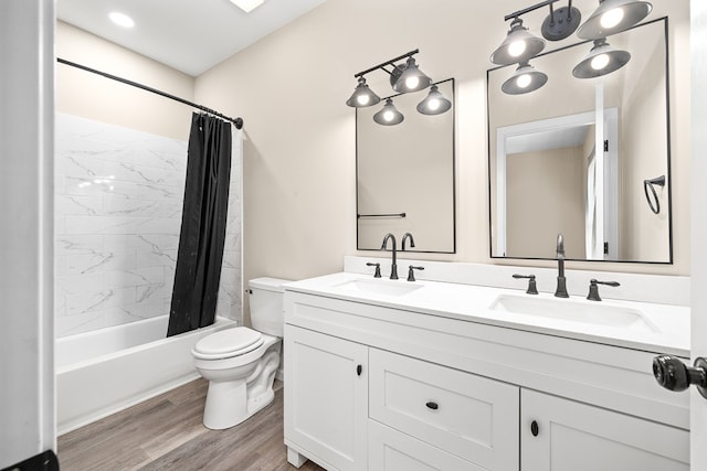 bathroom with wood finished floors, shower / tub combo, a sink, and toilet