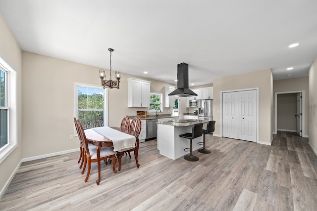 dining area with light wood-style floors, recessed lighting, a notable chandelier, and baseboards