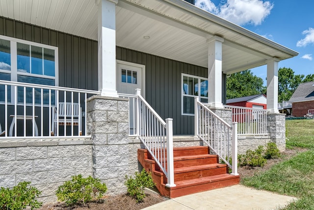 doorway to property with board and batten siding and a porch