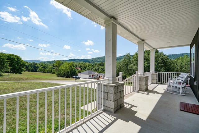 view of patio featuring a porch and a forest view