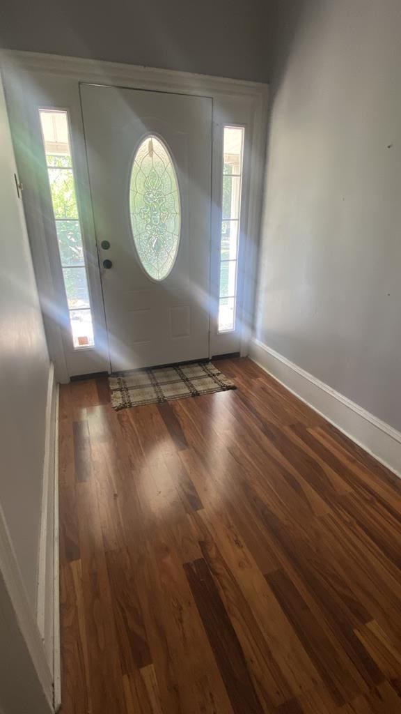 entryway with dark wood-style floors and baseboards