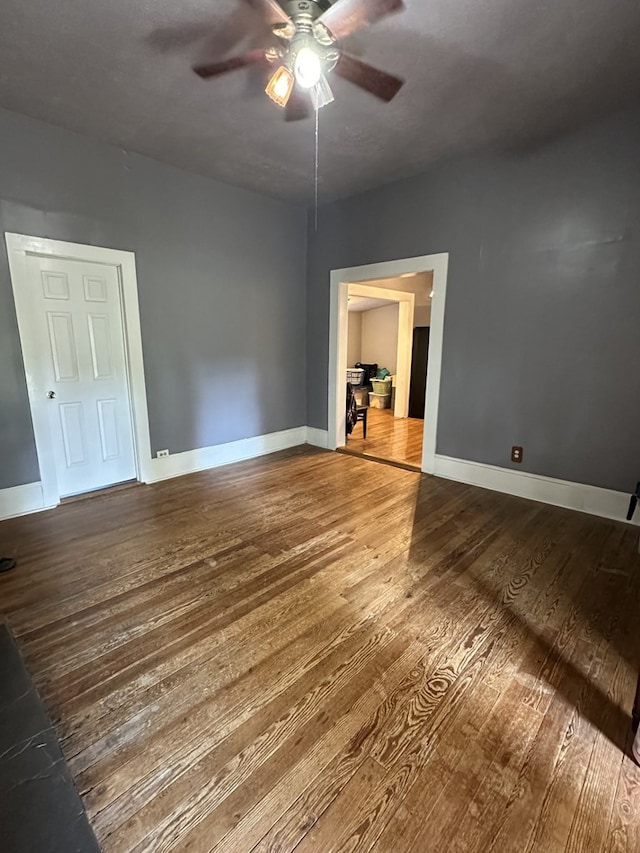 unfurnished room featuring ceiling fan, baseboards, and wood finished floors