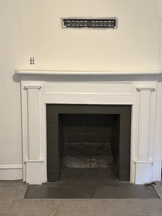 room details featuring a fireplace with flush hearth and carpet flooring