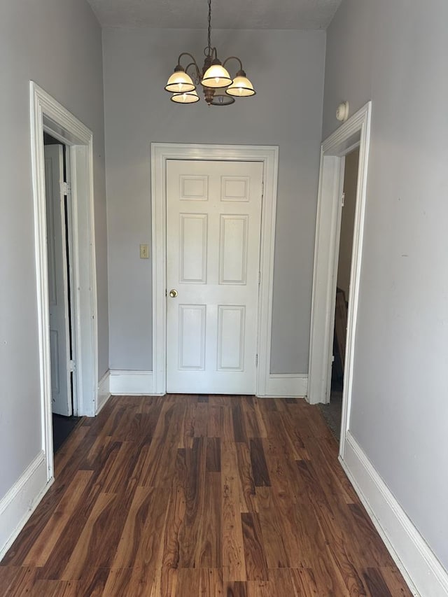 interior space featuring an inviting chandelier, visible vents, baseboards, and dark wood-style flooring