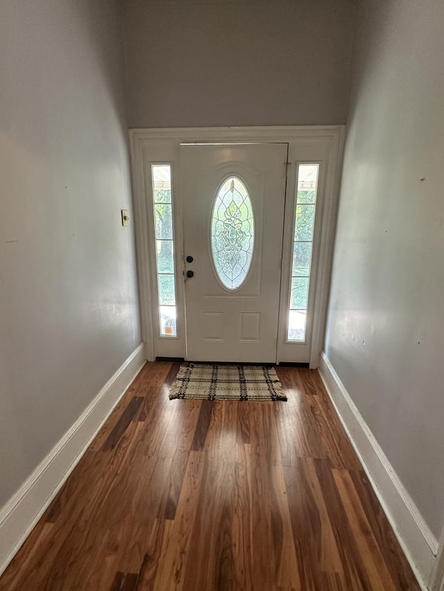 entryway with dark wood finished floors and baseboards