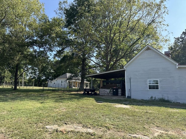 view of yard with an attached carport and fence