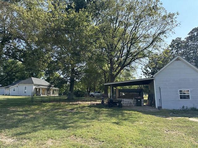 view of yard featuring fence and an attached carport