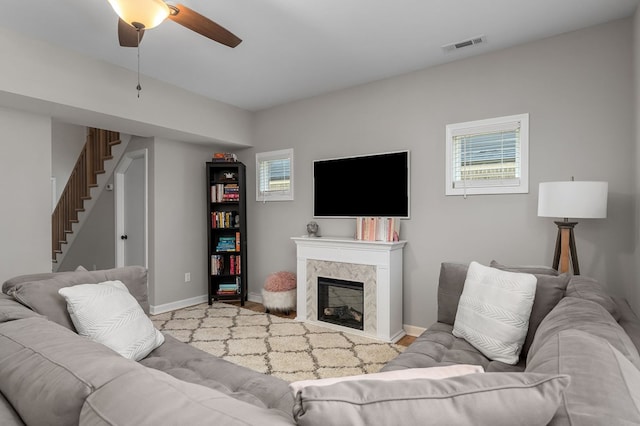 living area with stairway, baseboards, a premium fireplace, and visible vents