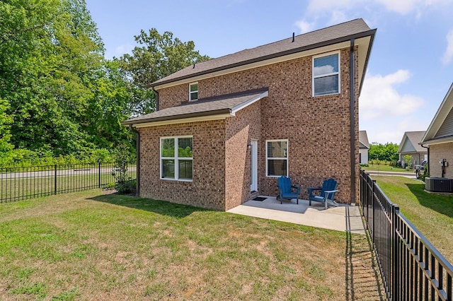 back of property featuring a patio, a yard, a fenced backyard, and brick siding