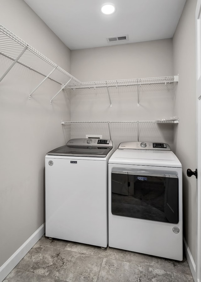 washroom with laundry area, baseboards, visible vents, and washer and clothes dryer