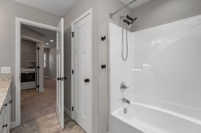 bathroom with shower / bathtub combination, a closet, vanity, washer / dryer, and baseboards