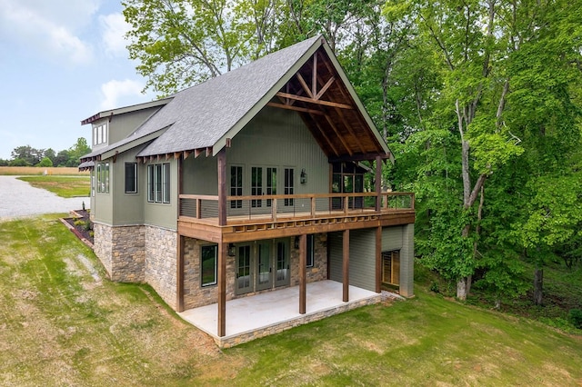 1036 Hidden River Rd, Rock Island, TN 38581 - rear view of house featuring stone siding, a yard, a patio, a shingled roof, and a deck