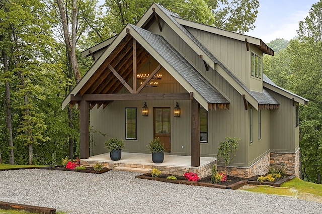 1036 Hidden River Rd, Rock Island, TN 38581 - chalet / cabin with covered porch, a shingled roof, stone siding, and board and batten siding