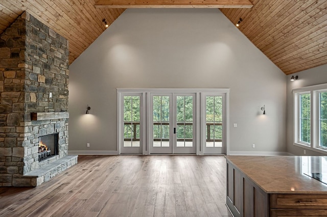 1036 Hidden River Rd, Rock Island, TN 38581 - unfurnished living room featuring high vaulted ceiling, hardwood / wood-style flooring, a stone fireplace, and a wooden ceiling with exposed beams