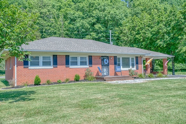 single story home featuring brick siding, roof with shingles, and a front yard