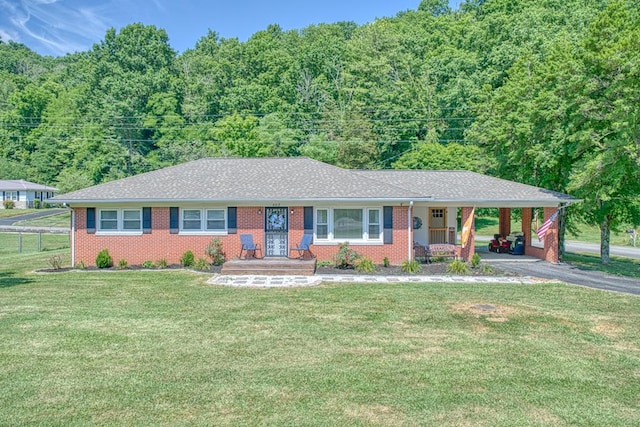 ranch-style house with an attached carport, a front yard, brick siding, and aphalt driveway