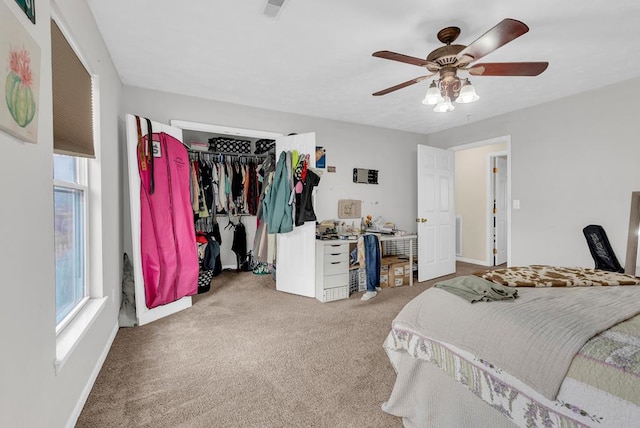 carpeted bedroom with multiple windows, a closet, a ceiling fan, and baseboards