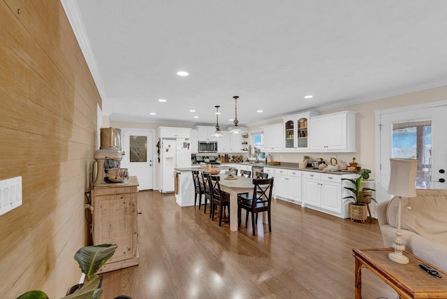 dining area with recessed lighting, crown molding, and wood finished floors