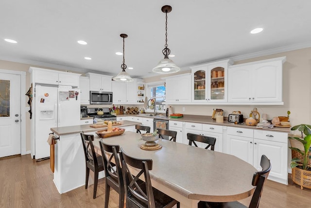 dining area with ornamental molding, recessed lighting, and light wood finished floors