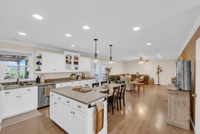 kitchen with light wood-style flooring, stainless steel dishwasher, ornamental molding, open floor plan, and a sink