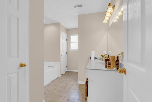 full bath with baseboards, visible vents, a bath, and vanity