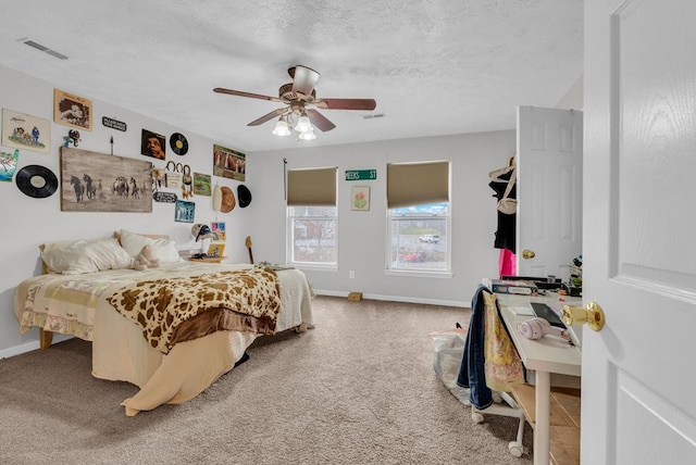 carpeted bedroom featuring visible vents, a textured ceiling, and baseboards