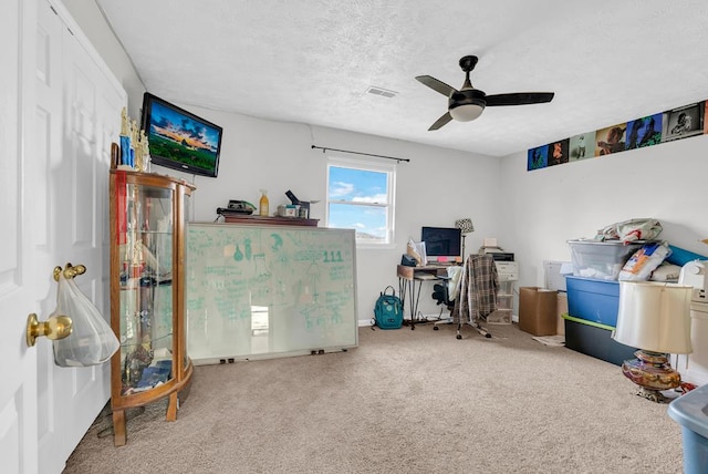 office space with ceiling fan, a textured ceiling, visible vents, and carpet flooring