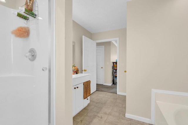 full bathroom with a bathtub, walk in shower, vanity, and baseboards