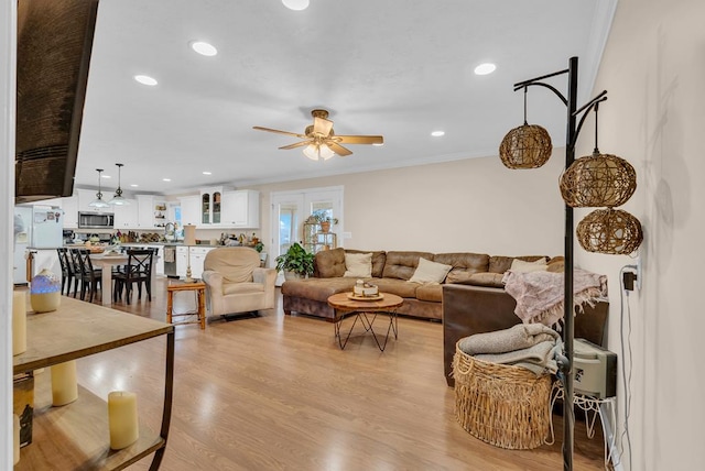 living area featuring light wood-type flooring, ceiling fan, ornamental molding, and recessed lighting