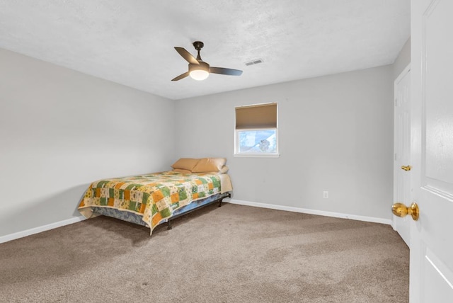 carpeted bedroom with a ceiling fan, visible vents, a textured ceiling, and baseboards