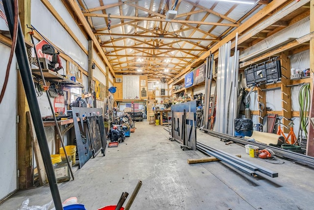 interior space featuring concrete flooring, a workshop area, and lofted ceiling