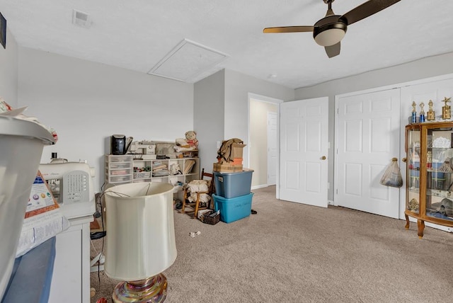 interior space with a ceiling fan, visible vents, and carpet flooring