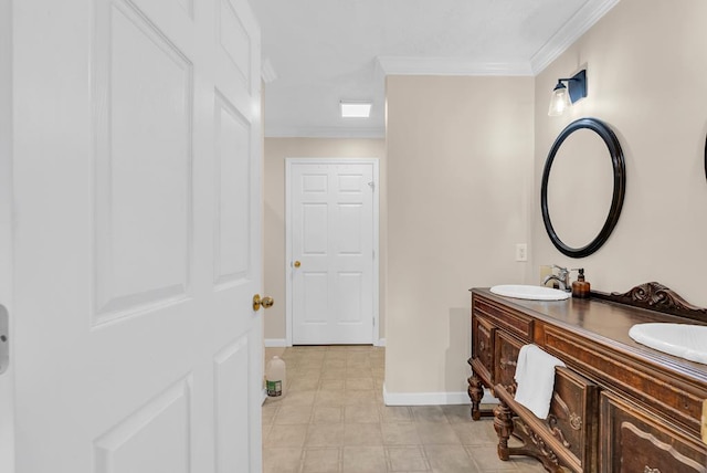 bathroom with double vanity, baseboards, ornamental molding, and a sink