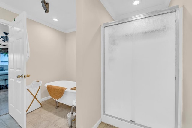 bathroom with a stall shower, a soaking tub, crown molding, and baseboards