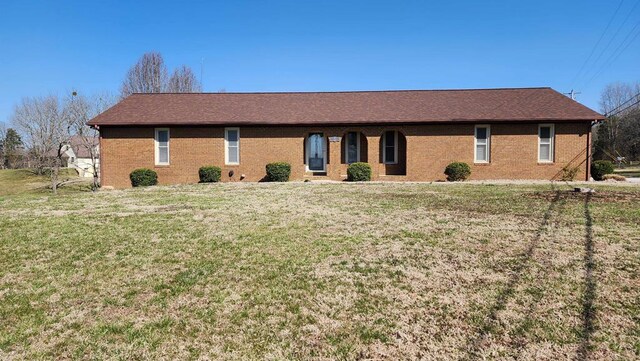 single story home featuring brick siding and a front lawn