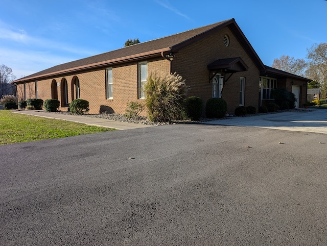 view of side of property with brick siding and an attached garage