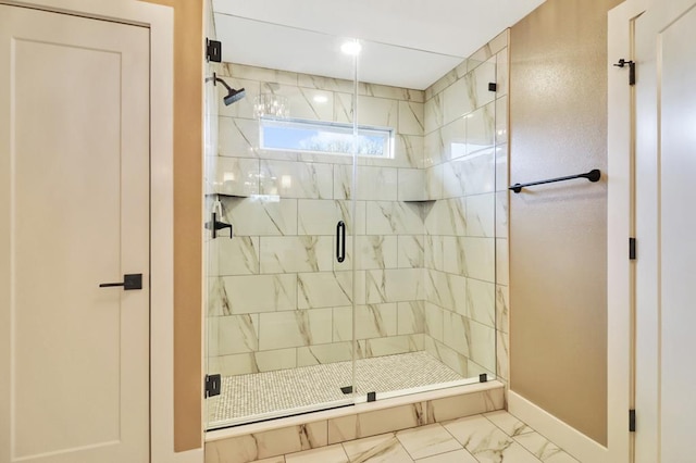 bathroom featuring a stall shower, marble finish floor, and baseboards