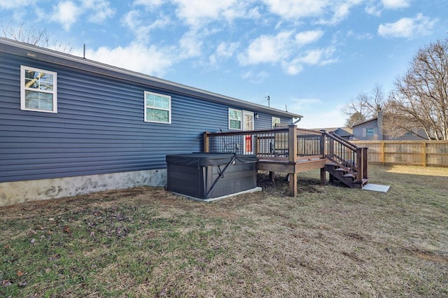 back of house with a deck, fence, stairs, a lawn, and a hot tub