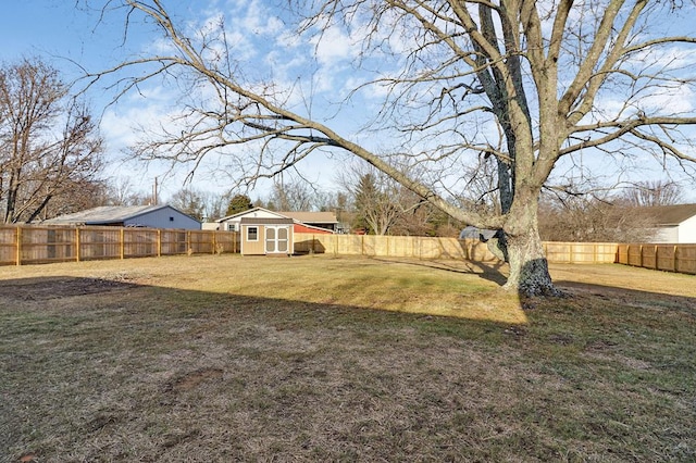 view of yard featuring an outbuilding, a storage unit, and a fenced backyard