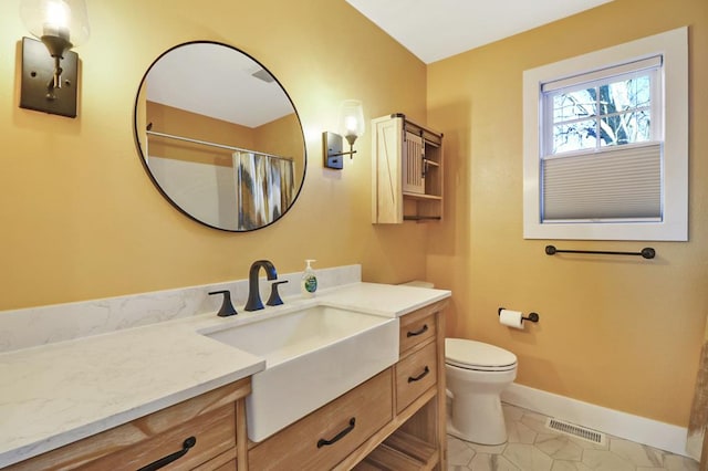 bathroom with visible vents, toilet, vanity, baseboards, and tile patterned floors