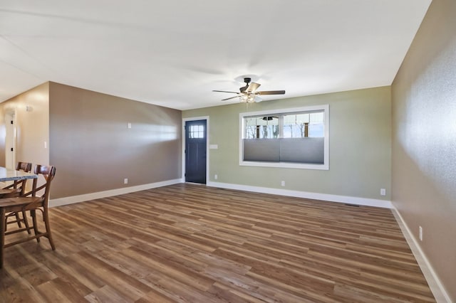 foyer featuring ceiling fan, dark wood-style flooring, and baseboards