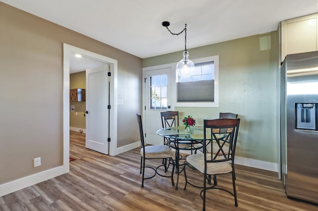 dining area with baseboards and wood finished floors