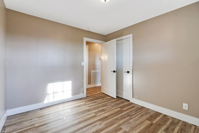 unfurnished room featuring light wood-style floors, baseboards, and visible vents