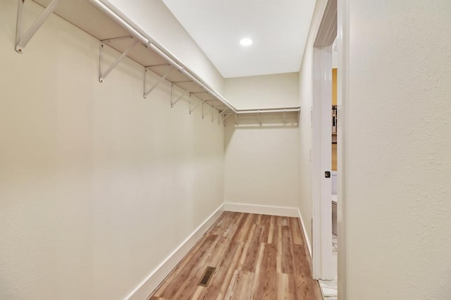 walk in closet with visible vents and wood finished floors