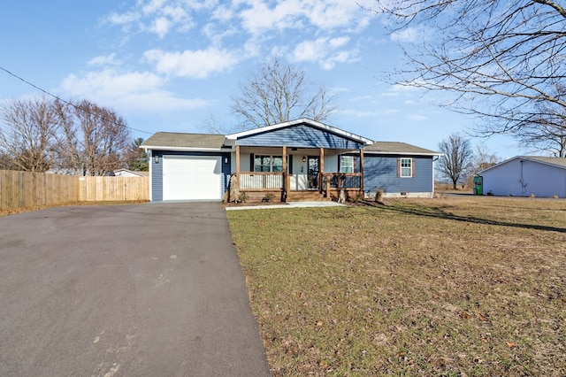 view of front of home featuring aphalt driveway, covered porch, fence, a garage, and a front lawn