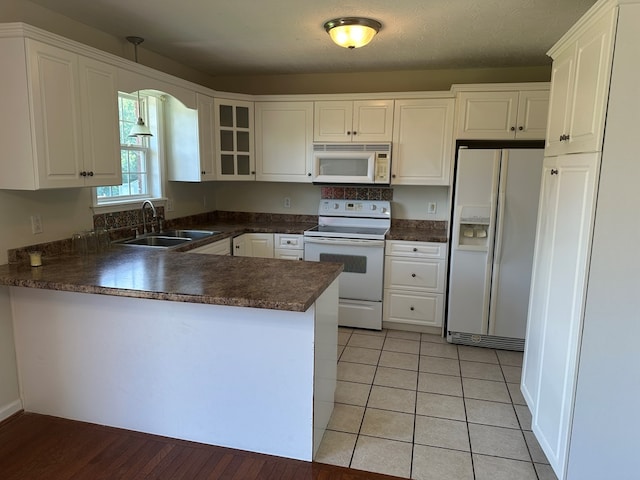 5514 Raven Xing, Baxter, TN 38544 - kitchen with white appliances, dark countertops, a peninsula, white cabinets, and glass insert cabinets
