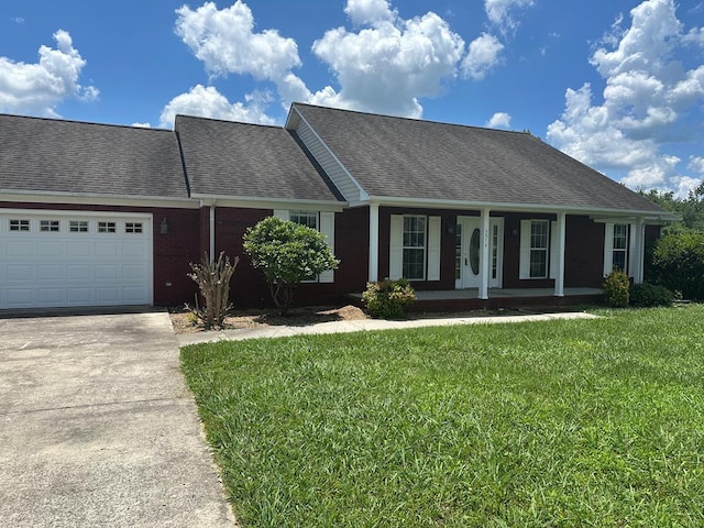 5514 Raven Xing, Baxter, TN 38544 - view of front facade featuring covered porch, a front yard, concrete driveway, and a garage