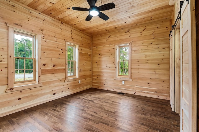106 Raccoon Ln, Jamestown, TN 38556 - empty room featuring dark wood-style flooring, a ceiling fan, wooden walls, a barn door, and wooden ceiling
