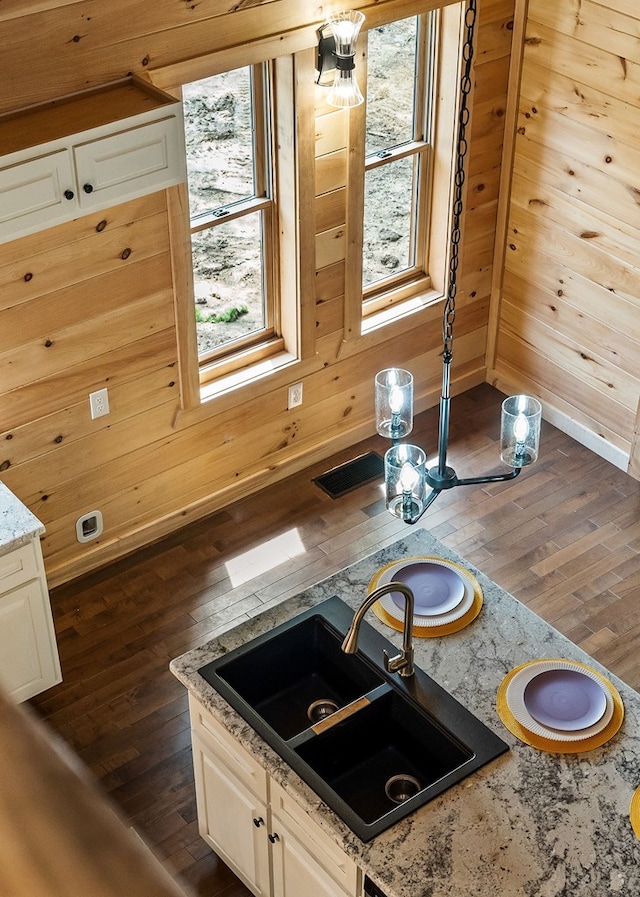 106 Raccoon Ln, Jamestown, TN 38556 - kitchen featuring dark wood-style floors, plenty of natural light, light stone counters, wooden walls, and white cabinetry