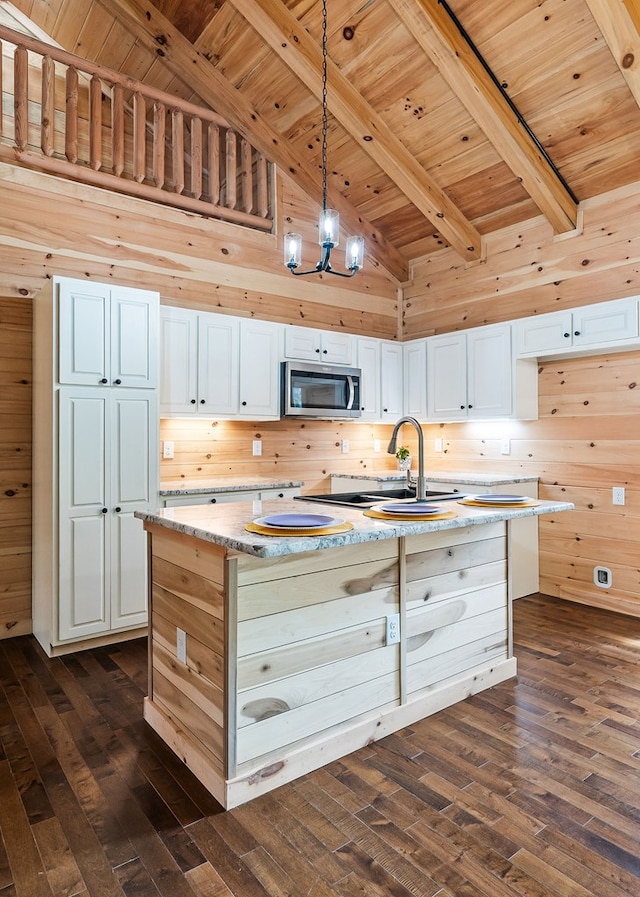 106 Raccoon Ln, Jamestown, TN 38556 - kitchen with stainless steel microwave, wooden ceiling, dark wood-style floors, an island with sink, and white cabinetry